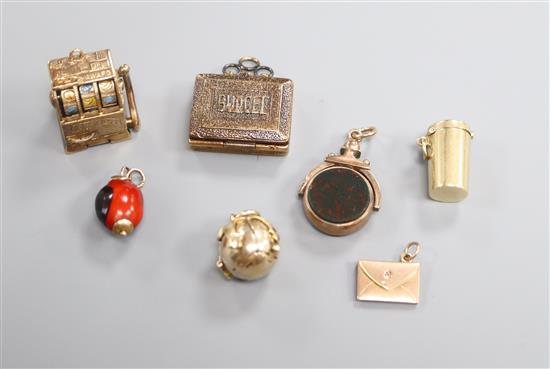 Seven assorted charms, including a 9ct gold fruit machine, a 9ct gold and bloodstone spinning fob, masonic ball etc.